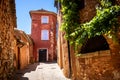 Roussillon: A narrow street in the beautiful French village of Roussillon, where the buildings are made with colorful, France Royalty Free Stock Photo