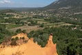 Roussillon ochre deposit red hills and green pines forest in Luberon