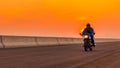 On the route to a summer vacation on a motorcycle, On an asphalt highway, a biker dude wearing a leather jacket and a helmet rides Royalty Free Stock Photo