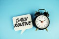 Daily Routine text on speech bubble with alarm clock on blue background Royalty Free Stock Photo