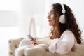 Daily routine. Young female with curly hair listening to music Royalty Free Stock Photo