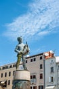 ROVINJ, CROATIA-AUGUST 30, 2018: Tourists walk by the Fountain with a sculpture of a boy and a fish and a clock Tower on Royalty Free Stock Photo