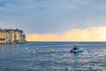 Rovinj, Croatia; 7/18/2019: Boat sailing in the Adriatic Sea during sunset of a cloudy day with the typical croatian houses on the Royalty Free Stock Photo