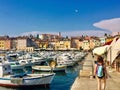 A view of the waterfront of Rovinj, Croatia full of colourful old buildings and boats docked in the bay.