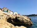 The rocky shores of the old town of Rovinj, Croatia along the Adriatic Sea. Locals and tourists are swimming Royalty Free Stock Photo