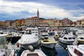 Rovinj, Croatia; 7/18/2019: Port of Rovinj with a lot of boats at the foreground and the old town and the tower of the Church of