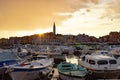 Rovinj, Croatia; 7/18/2019: Sunset in Rovinj, with a lot of boats anchored in the port and the old town at the background, with