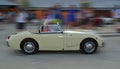 Classic White Austin Healey Frog eye Sprite being driven through town square in Rovinj in tour of Croatia.