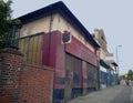 A row of abandoned stores with boarded up shop fronts with crumbling facades and peeling paint in an urban road Royalty Free Stock Photo
