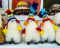 Row of alpaca plush toys with traditional rainbow-colored hats, Pisac traditional market, Peru