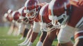 A row of American football players in red helmets and jerseys lining up on the field Royalty Free Stock Photo