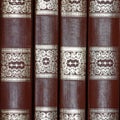 A row of antique books with gilded pattern as texture background