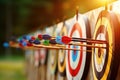 Row of archery targets with arrows in the bullseye, colorful fletchings in focus. Warm sunlight bathing the scene Royalty Free Stock Photo
