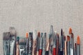 Row of artist paint brushes and palette knife on canvas Royalty Free Stock Photo