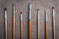 Row of artist paintbrushes closeup on sack, retro stylized
