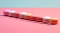 Row of assorted French macarons against a pink background