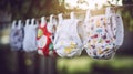 A row of baby diapers hanging from a clothes line. Generative AI image.