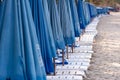 row of beach beds with blue umbrellas Royalty Free Stock Photo