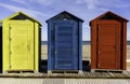 Row of beach huts cabins in front of beach see and sand