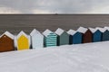 Row of beach huts in winter snow on coast of Herne Bay, Kent, En Royalty Free Stock Photo