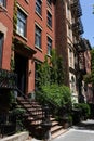 Row of Beautiful Old Brick Residential Buildings with Green Plants along a Sidewalk in the East Village of New York City Royalty Free Stock Photo