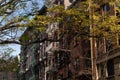Row of Beautiful Old Residential Buildings with Fire Escapes in Nolita of New York City with a Colorful Tree during Autumn