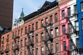 Row of Old Colorful Brick Residential Buildings in Hell`s Kitchen of New York City with Fire Escapes Royalty Free Stock Photo