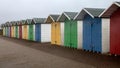 Row of beautiful wooden huts painted green, red, yellow and blue at the beach in Eastbourne, England