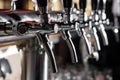 A row of beer taps in a beer bar close-up. Beer bottling in the restaurant. Royalty Free Stock Photo