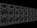 Row of big matte black concert music loudspeakers with skulls in the center of speakers