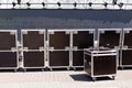 Row big metal boxes with professional sound equipment. Preparing for mass event on city street. Transportation of concert or Royalty Free Stock Photo