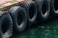 Row of black car tires used as boat bumpers