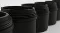 A row of black cylindrical containers with a slightly curved top. Royalty Free Stock Photo