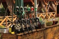 A row of black hookahs standing on a brown wooden table of an open summer restaurant