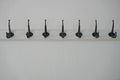 A row of black hooks on a white wooden ledge on the wall Royalty Free Stock Photo