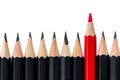 Row of black pencils with one red pencil in middle Royalty Free Stock Photo