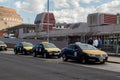 Row of black and yellow taxi cabs waiting for customers on taxi rank outside terminal building Royalty Free Stock Photo