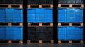 A row of blue and black plastic containers on wooden pallets. Royalty Free Stock Photo