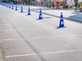 Row of Blue Plastic Traffic Cones on Asphalt Street Royalty Free Stock Photo