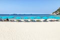 Row blue umbrellas with wooden beach chairs on tropical sandy beach in sunny day Royalty Free Stock Photo