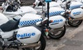 Row of blue and white police motor cycles parked in city street