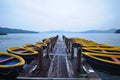 Row boats and wooden jetty in the morning at peaceful lake Royalty Free Stock Photo