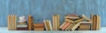 Row of books,hardback books on wooden table on blue background. Back to school,education,reading, home office. Panoramic, large Royalty Free Stock Photo