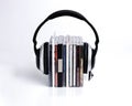 Row of books with headphones isolated on a white background- audiobook concept Royalty Free Stock Photo