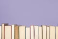 Row of books on a lavender purple background Royalty Free Stock Photo