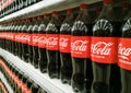 Row of bottles of Coca-Cola original taste on a shelf in a store