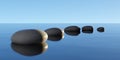 Row, bow or line of black pebbles with water on blue sky background, zen, spa, yoga or meditation concept Royalty Free Stock Photo