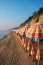 a row of bright beach umbrellas on the coast