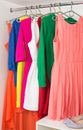 Row of bright colorful dress hanging on coat hanger, shoes Royalty Free Stock Photo