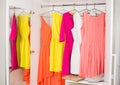 Row of bright colorful dress hanging on coat hanger, shoes and h Royalty Free Stock Photo